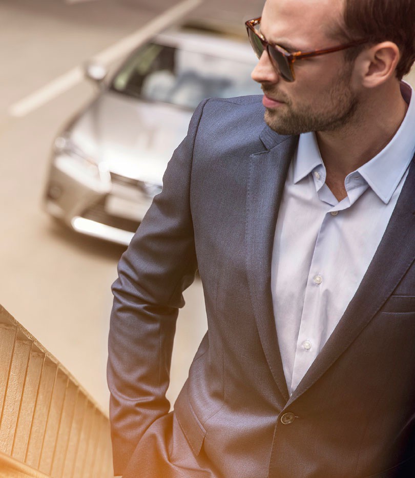 man looking right with a Lexus car behind him