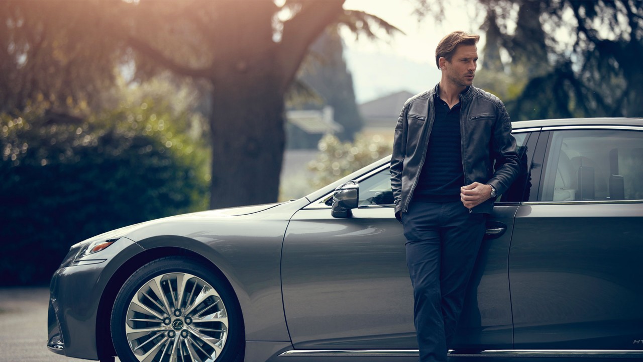 man leaning on a Lexus car