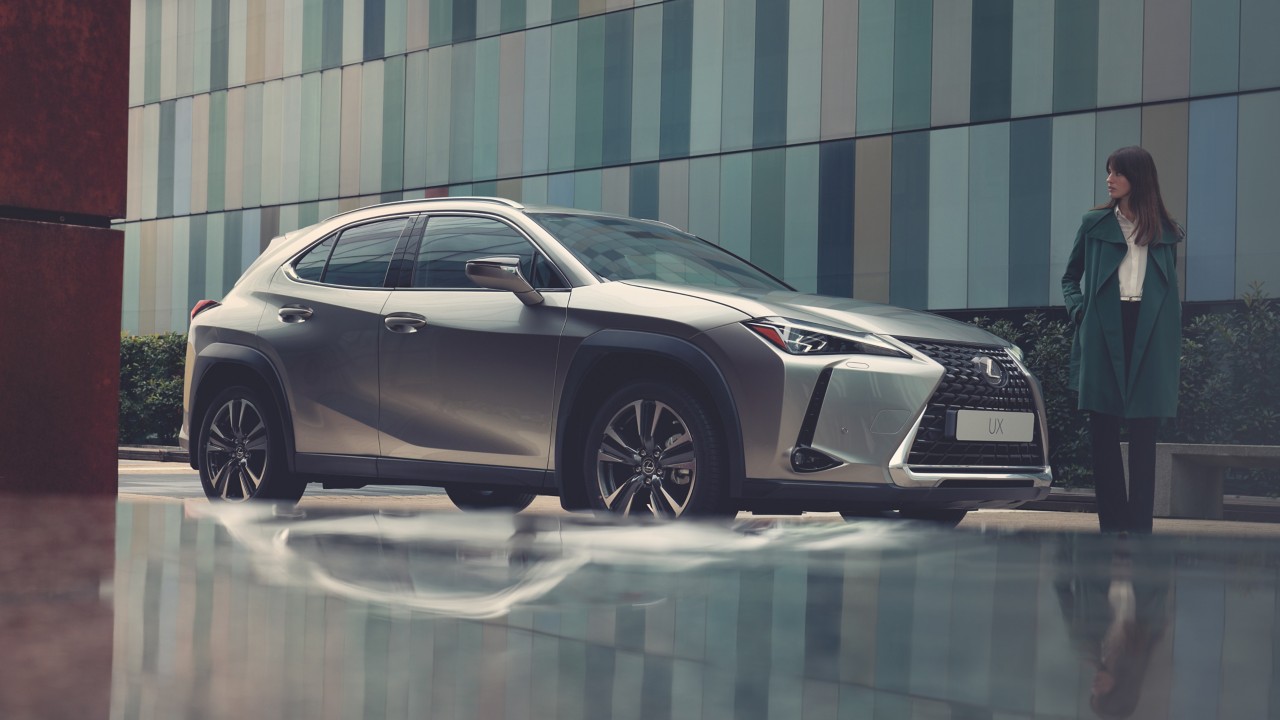 woman standing next to a Lexus car