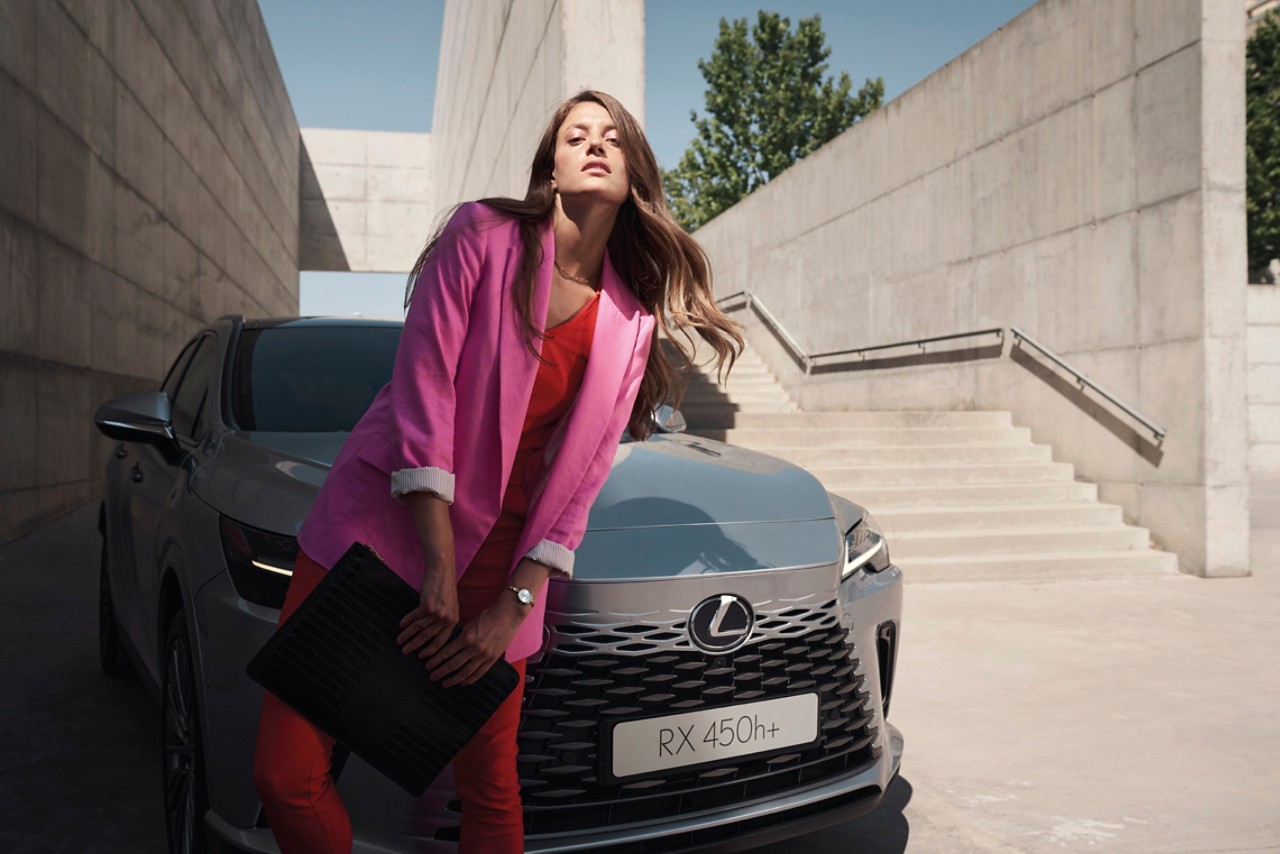 woman standing next to a Lexus UX 