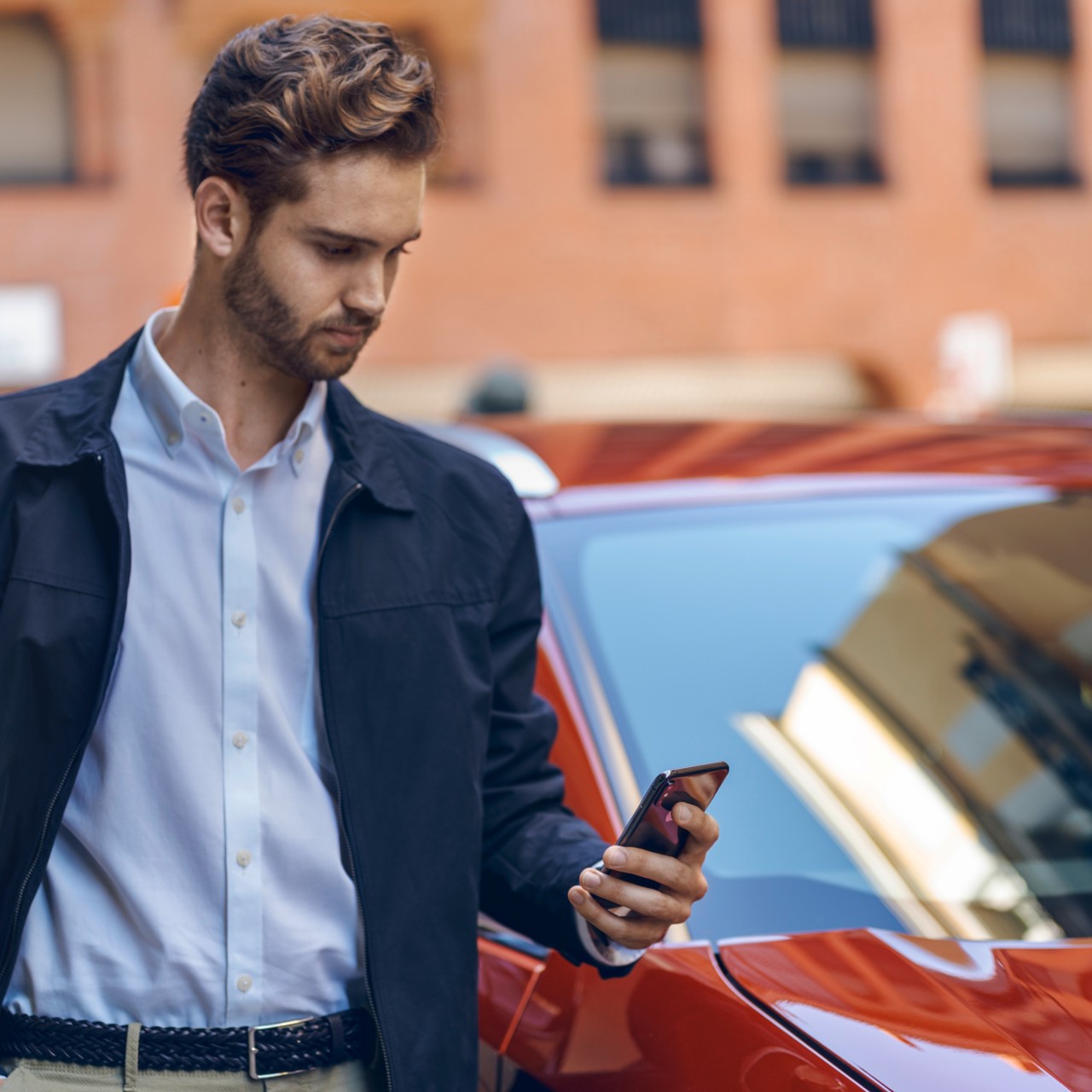 man on mobile phone standing next to Lexus car