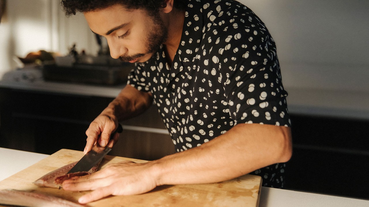 man cutting something on a chopping board