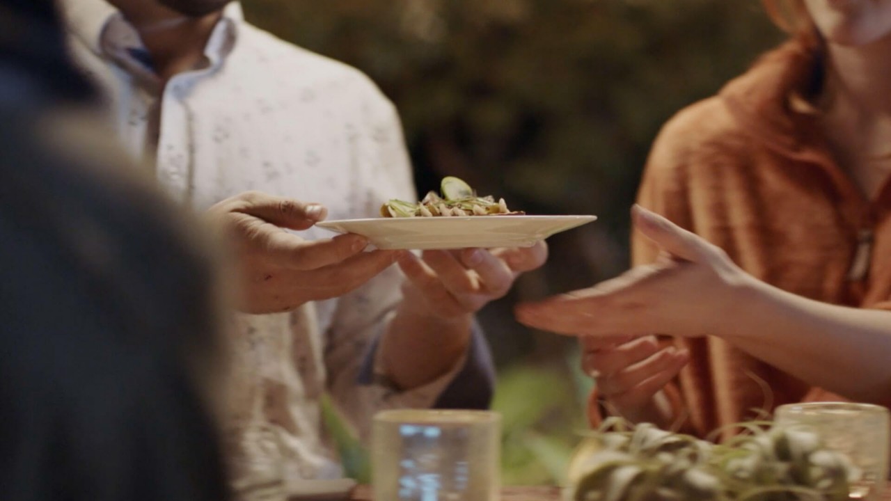 people exchanging a plate of food