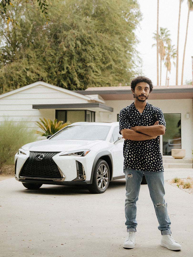 Miles Thompson standing in front of a Lexus UX