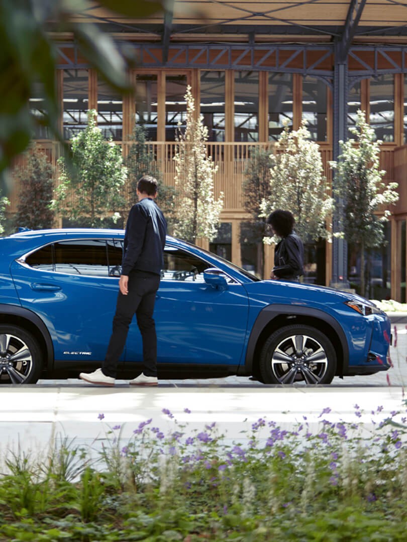 person entering their parked Lexus UX 300e car