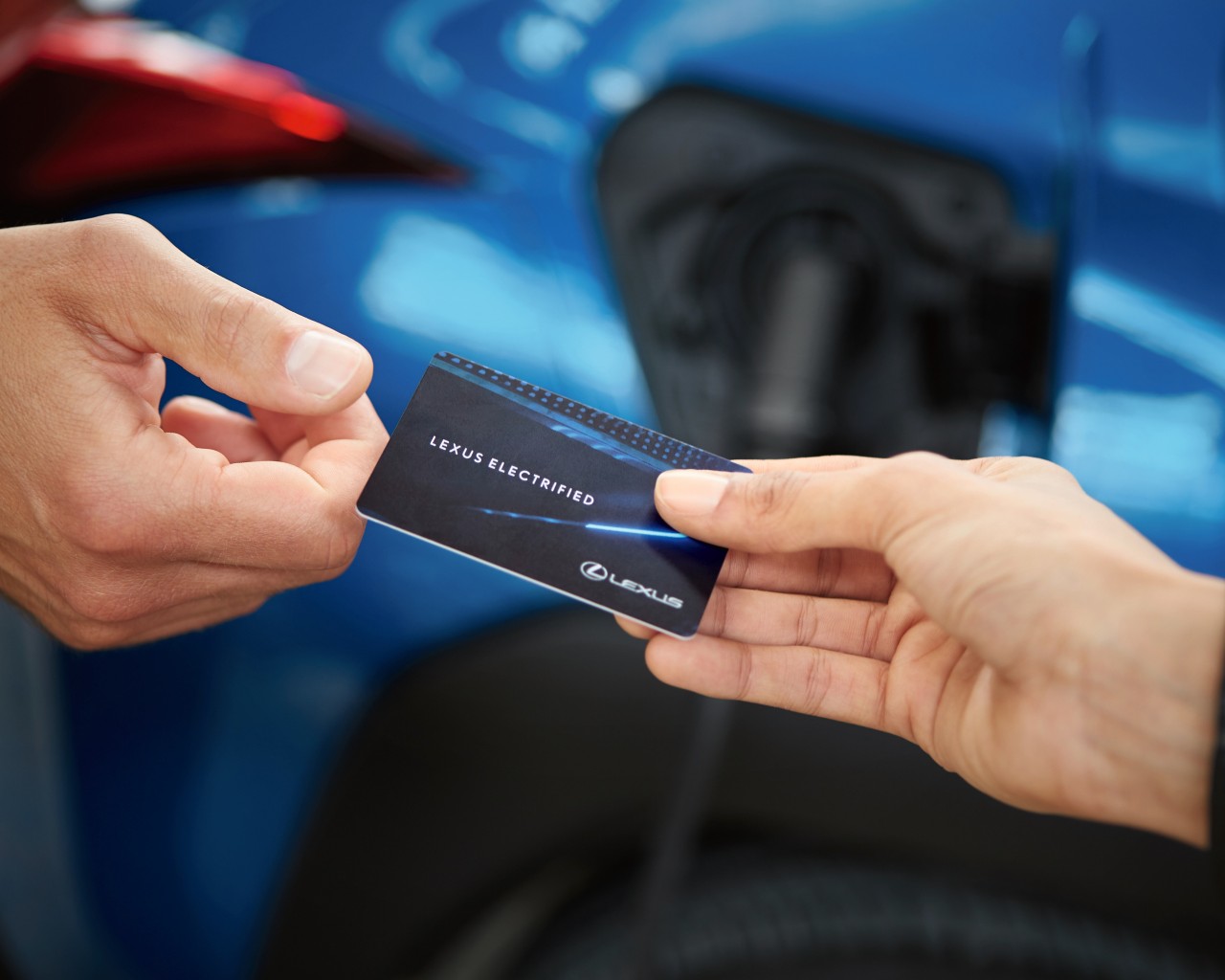 two people exchanging a Lexus electrified card