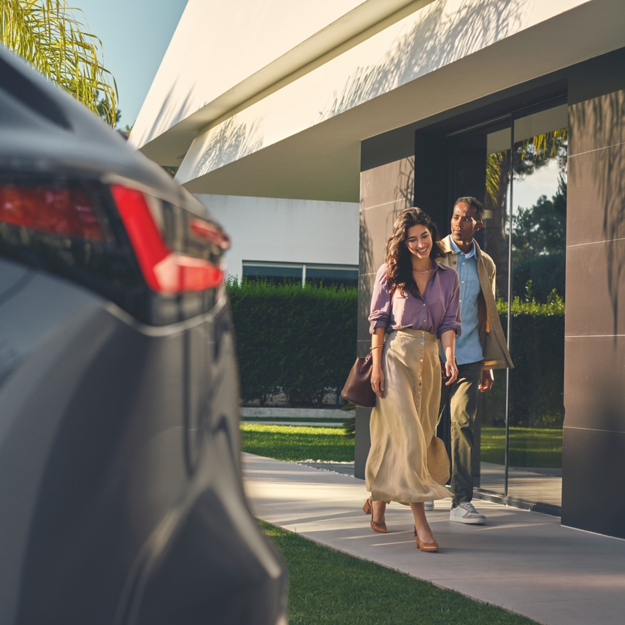 two people walking towards a Lexus car