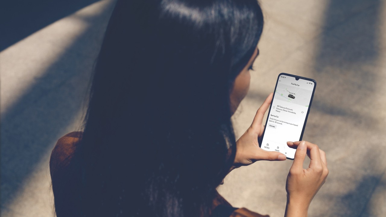 woman looking at a Lexus NX on a phone