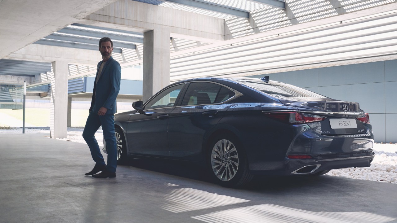 man standing next to a Lexus ES