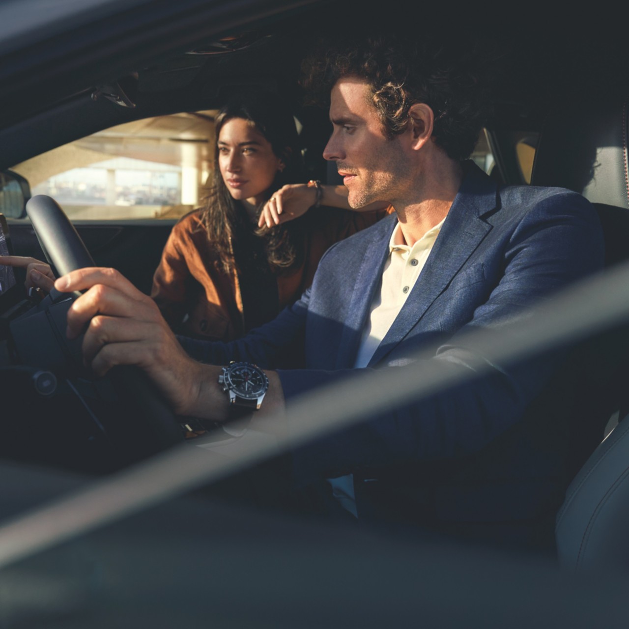 two people driving a Lexus car