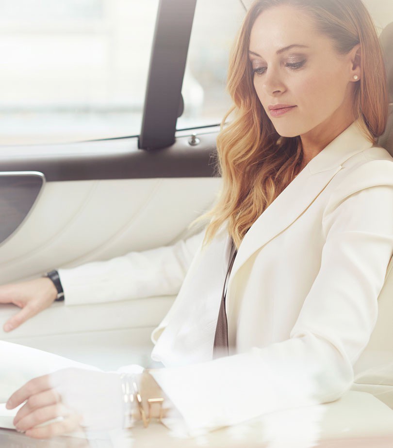 woman with a white suit sitting inside a Lexus car