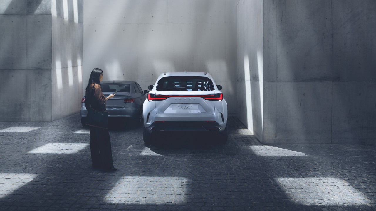 woman standing next to a parked Lexus NX 350h