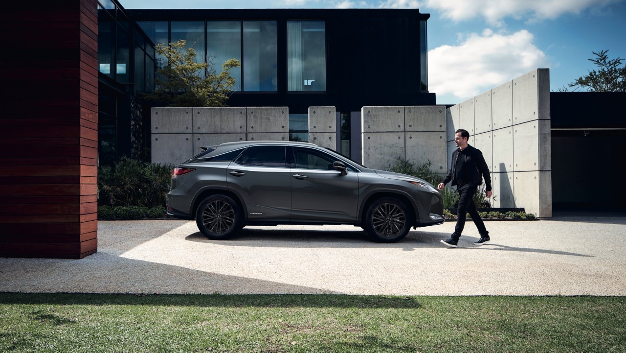 man in suit standing next to a Lexus RX