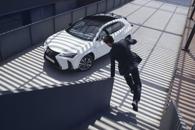 woman sitting in front of a Lexus car