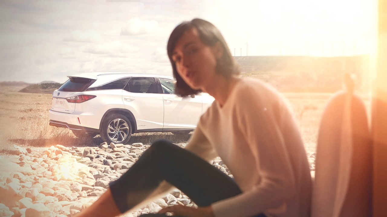 woman sitting in front of a Lexus car