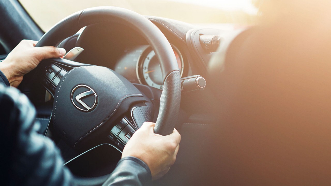 two hands on a Lexus steering wheel