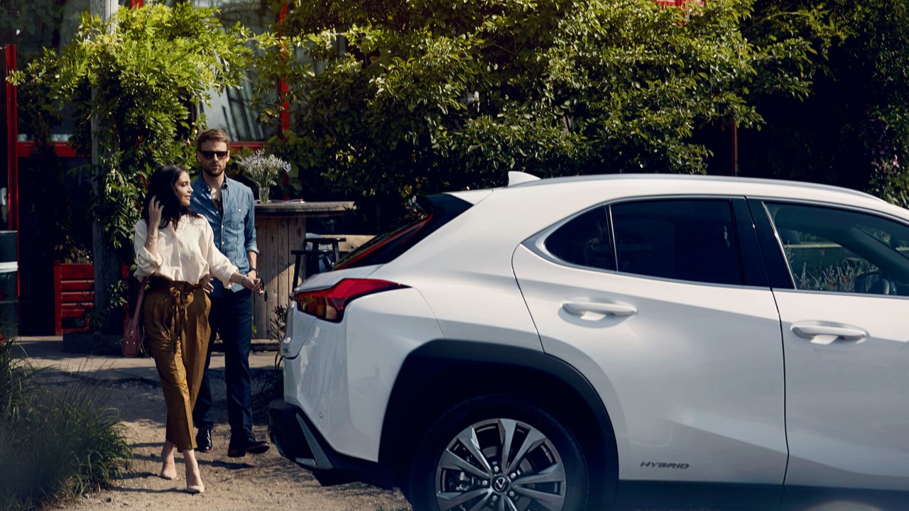 two people walking towards a Lexus car