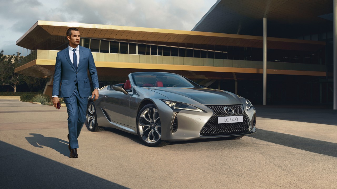 A man walking away from a Lexus LC Convertible